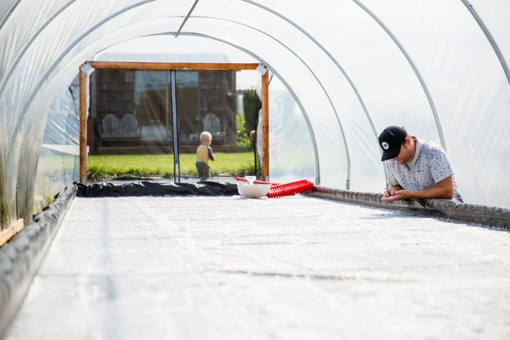 Brady Ryan inspects the harvest while his son plays outside. Photo by La Vie Photo.