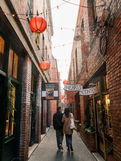 Couple wander through Fan Tan Alley in Victoria. Photo by Destination BC and Jordan Dyck