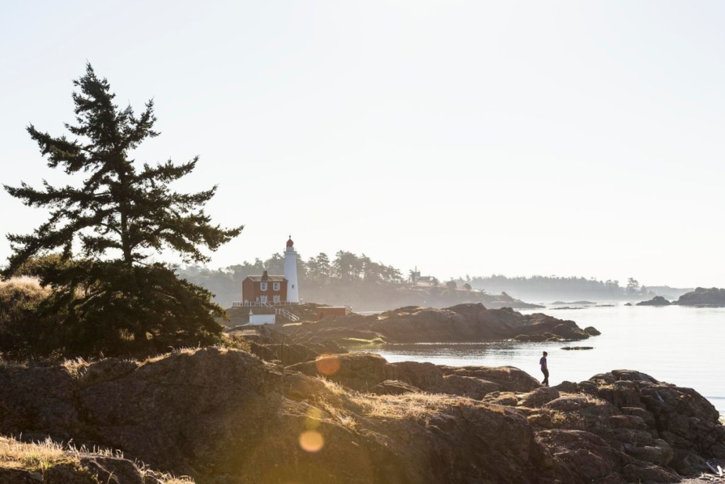A person hiking on the rocks near Fisgard Lighthouse National Historic Site. Photo provided by Destination BC and Reuben Krabbe