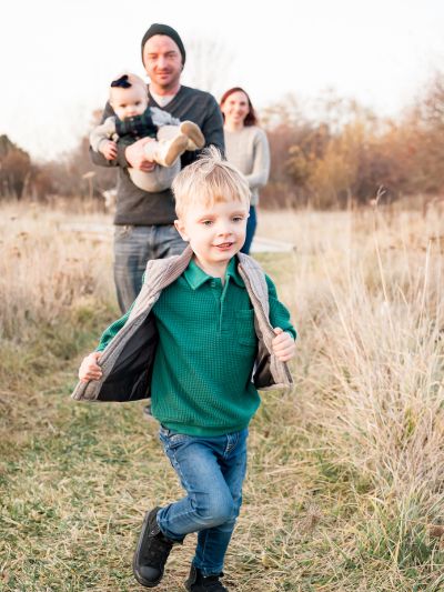 Boy running with family. Andrea Huss